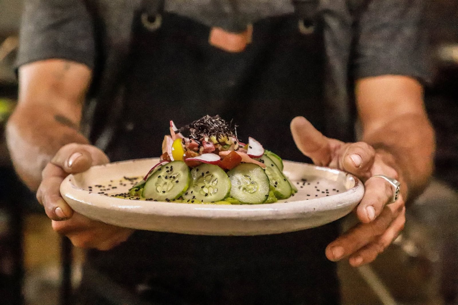 Plato preparado sostenido por el cocinero al salir de la cocina