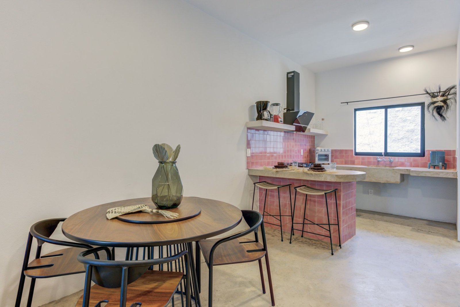 Cocina y comedor de Jengibre con barra de talavera rosa y campana