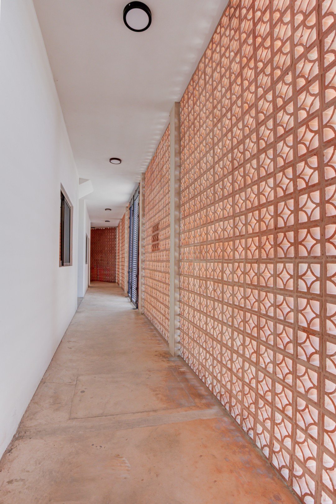 Pasillo interior de Mamica La Cruz con muro de celosía de barro