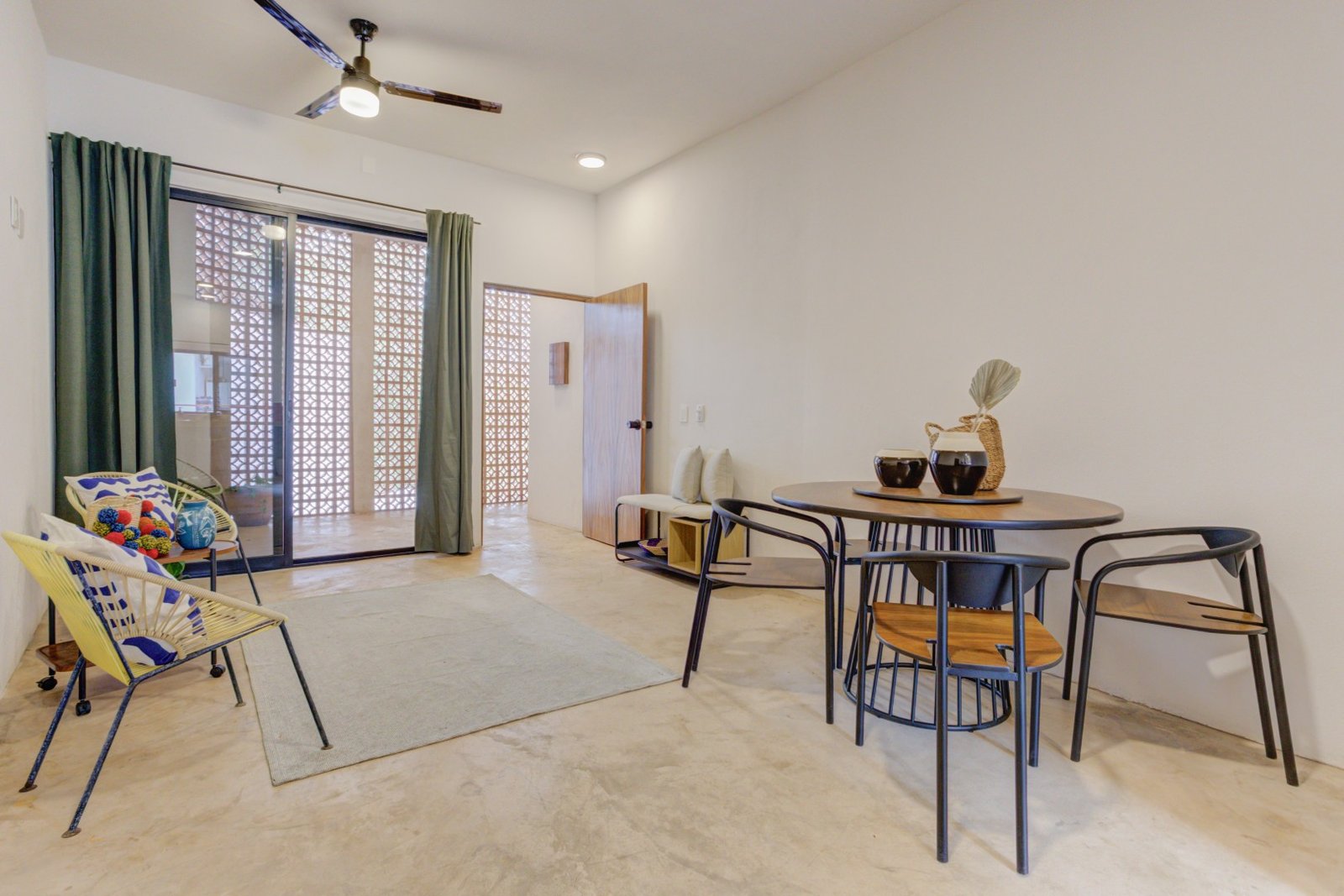 Sala y comedor de Bugambilia con puerta de celosía y ventilador de techo