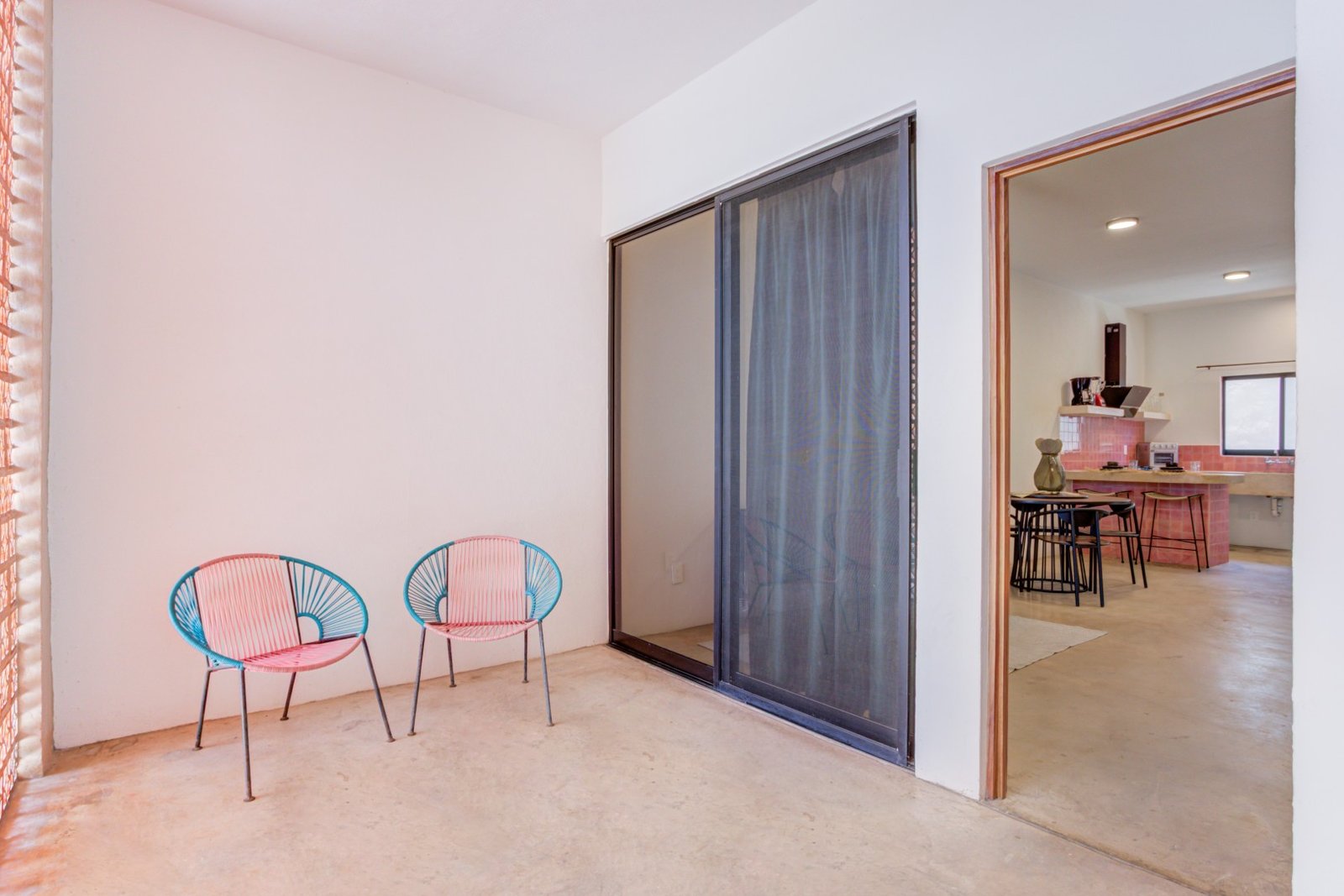 Sala con sillón y ventanal hacia el balcón