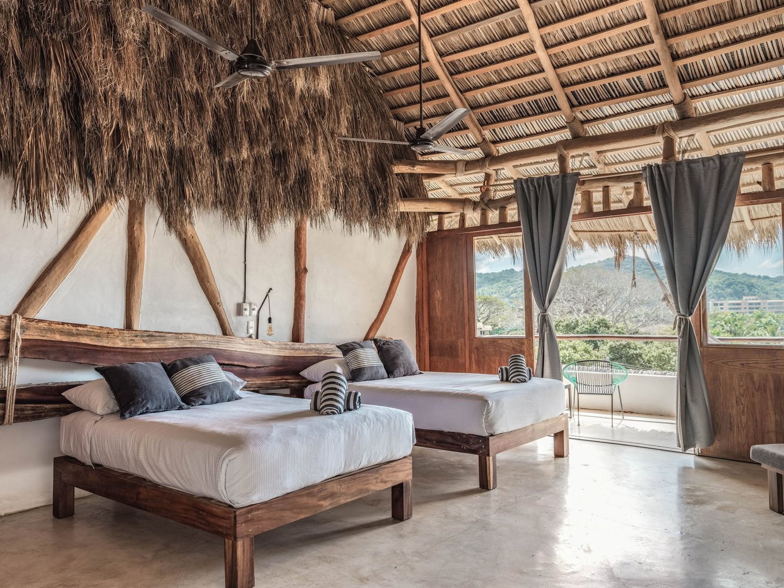 Habitación con dos camas matrimoniales y ventanal con vista a la sierra